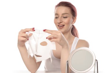 Beyaz arka planda makyaj fırçası olan güzel bir genç kadın.