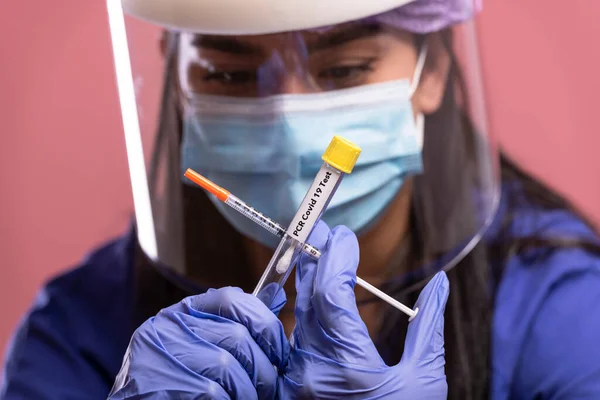 young woman in medical mask and gloves holding a syringe with a vaccine in her hand