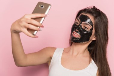 Yüzünde makyaj ve maske olan genç bir kadın, cadılar bayramı konsepti