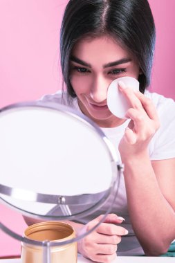 Makyajlı ve yüzünde fırça olan güzel bir kadın.