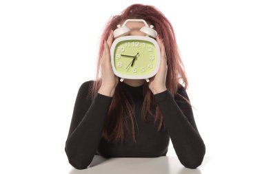 Beyaz arka planda çalar saati olan genç bir kadın.