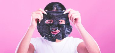 Maskeli ve yüzünde kocaman gözleri olan genç bir kadın.