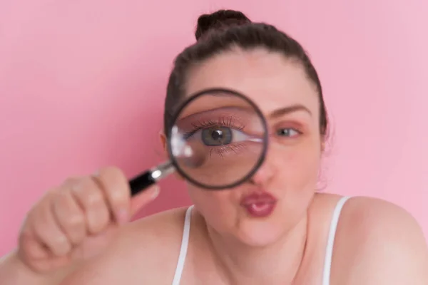 Mujer Joven Con Lupa Sobre Fondo Rosa —  Fotos de Stock