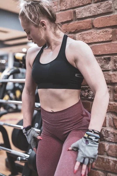 young woman with a barbell in the gym