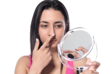 Beyaz arka planda makyaj fırçası olan genç bir kadın.