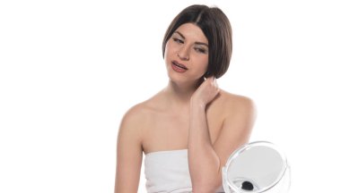 Yüzünde havlu olan güzel bir kadın, beyaz arka planda soyutlanmış.