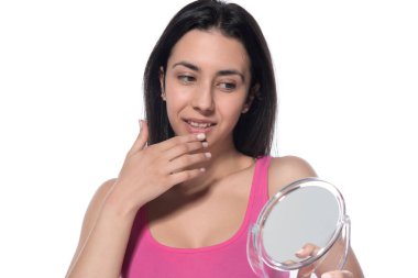 Beyaz arka planda makyaj fırçası olan genç ve güzel bir kadın.