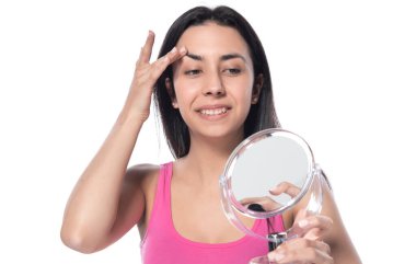 Makyajlı ve fırçalı genç bir kadın beyaz arka planda izole edilmiş.