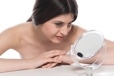 Güzel genç bir kadın yüzüne kozmetik krem sürüyor.