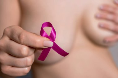 Göğüs kanseri farkındalığı kurdelesi ve siyah arka planda pembe kurdeleler.