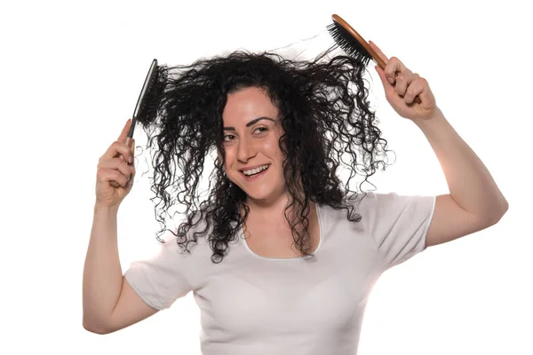 一个年轻的女人 梳着头发 剪着剪刀 与白色隔离 — 图库照片