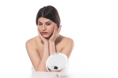 Genç bir kadın beyaz arka plana kozmetik krem sürüyor.