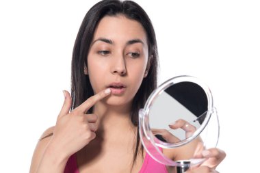 Güzel genç bir kadın beyaz arka plana makyaj yapıyor.