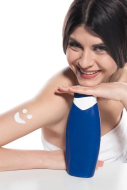 Yüzünde havlu olan güzel genç bir kadın, beyaz arka planda soyutlanmış.