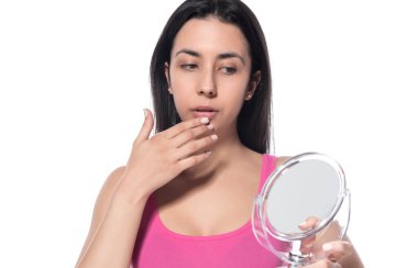 Beyaz arka planda makyaj fırçası olan güzel bir genç kadın.