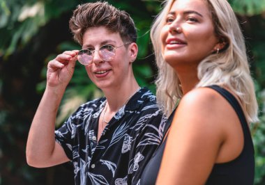 Birbirlerine aşık genç bir çift pencerenin arkasında sarılıp öpüşüyorlar.