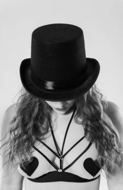 Siyah şapkalı, beyaz gömlekli, kovboy eli olan genç bir kadın.