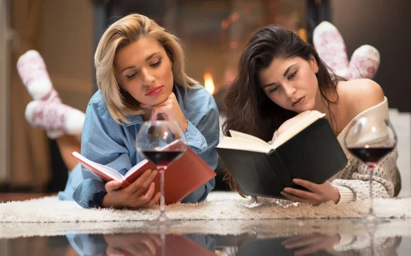 two beautiful women reading a book in the room