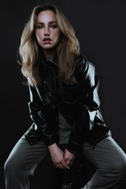 Stüdyoda poz veren uzun saçlı güzel bir genç kadın.