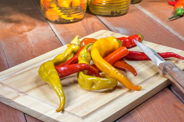 Bıçak ile kesme tahtası üzerinde turşu biber biber korunmuş