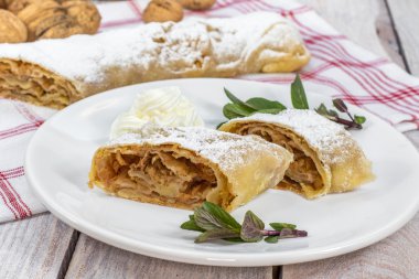 İki dilim ev yapımı elma Strudel krem şanti ile bir plaka üzerinde 