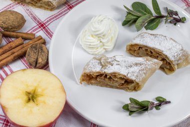 İki dilim ev yapımı elma Strudel krem şanti ile bir plaka üzerinde,