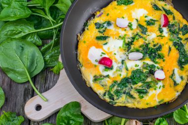 Ahşap masa, üst üzerinde tavada ıspanaklı omlet üzerinde ayrıntılı Vie