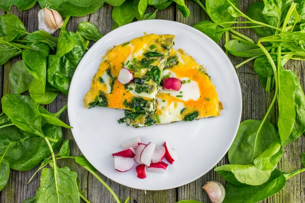 Beyaz tabakta turp ile bir ıspanaklı omlet üzerinde Üstten Görünüm 