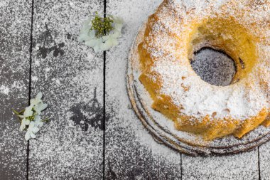 Koyu Ahşap Tabl Üzerinde Şeker ve Çiçek ile Bundt Kek Top View