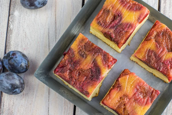 Gedetailleerde bovenaanzicht op pruimen taart met kaneel op kleine bakken tra — Stockfoto