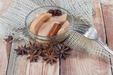 Yıldız anason ve Cinnamo ahşap masada çatal ile armut kompostosu