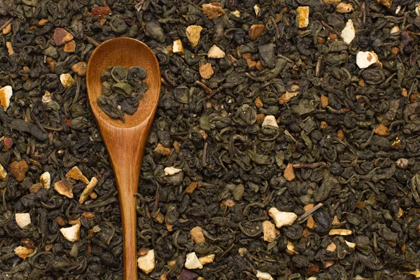Зеленые чайные листья с цитрусовыми и фрукты с деревянной ложкой — стоковое фото