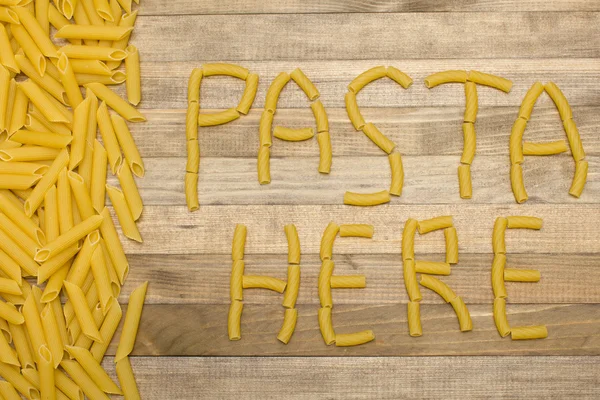 Pasta здесь текст из сырой пасты — стоковое фото