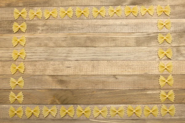 Borde hecho de pasta en forma de arco crudo — Foto de Stock