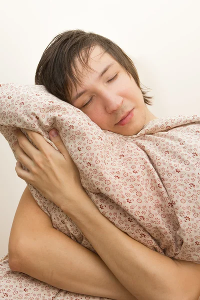 Sleeping  young  man hug big pillow — Stock Photo, Image