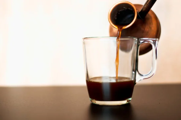 Taza de vidrio con café en una mesa negra —  Fotos de Stock