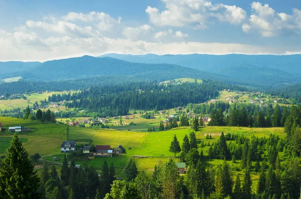 Sunny landscape of mountains, fields, trees, villages and blue sky with clouds — Stock Photo, Image