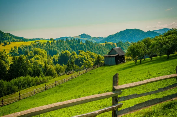 Złożony letni krajobraz, ogrodzenie wzdłuż górskich łąk gór — Zdjęcie stockowe