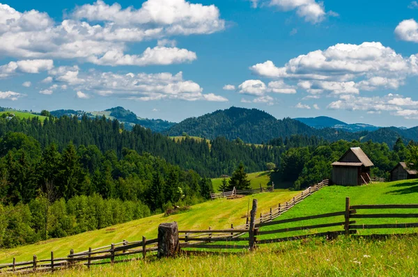 Złożony letni krajobraz, ogrodzenie wzdłuż górskich łąk gór — Zdjęcie stockowe