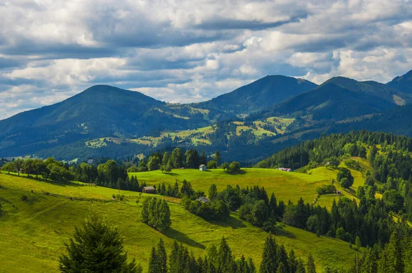 Niesamowity poranny krajobraz górski ze stogami siana na łąkach — Zdjęcie stockowe