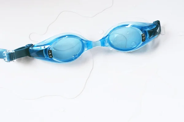 Blaue Kurzsichtigkeitsbrille Und Badeanzug Auf Dem Nassen Boden Eines Schwimmbades — Stockfoto