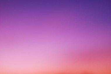 Sabahın erken saatlerinde gün doğumundan önce gökyüzü. Ufukta yumuşak mor, pembe ve turuncu ışık görünüyor. Arkaplan için renkli pastel tonlu boş doğal gökyüzü. Modern modda canlı renkler.