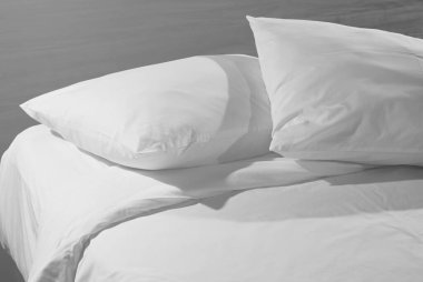 Beyaz yatak odasının yumuşak ve sakin atmosfer görüntüsü. Yastıklar ve battaniyeler boş yatağa, kapatın. Yatak ve kahvaltı işi geçmişi.