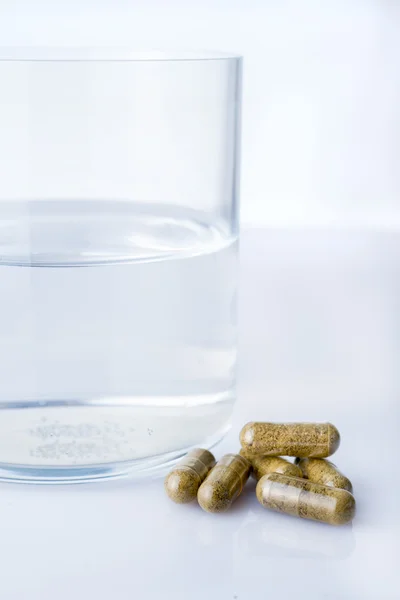 Ein Glas Wasser mit Homepathie-Pillen — Stockfoto