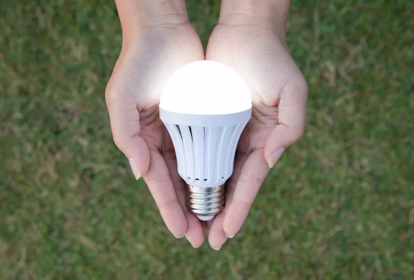 LED-Lampe mit Beleuchtung - Spartechnik in der Hand — Stockfoto