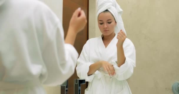 Mulher com toalha macia na cabeça lava rosto no banheiro — Vídeo de Stock