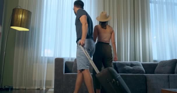 Alegre chico y mujer con maleta entrar en la habitación del hotel — Vídeos de Stock