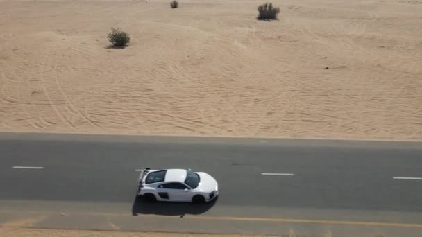 Coche deportivo de conducción en un camino desierto — Vídeos de Stock