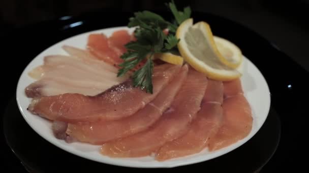 Fish sliced on a plate on a black background — Stock Video