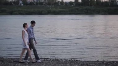Nehri boyunca gün batımında yürüme Çift